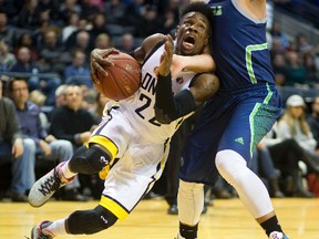 Tyshawn Patterson of the London Lightning drives through the arm of Sammy Zeglinski of the Niagara River Lions during the third quarter of their NBL of Canada game at Budweiser Gardens on Thursday night. The Lightning won 107-93. (Mike Hensen/The London Free Press)