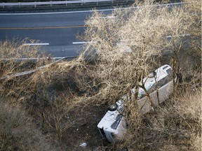 A bus lies after it veered off to the opposite lane on a mountain road in Karuizawa, Nagano prefecture, central Japan Friday, Jan. 15, 2016. Rescue officials say the overnight tour bus on its way to a ski resort in central Japan slid down the mountainside, killing at least more than a dozen passengers. (Kyodo News via AP)