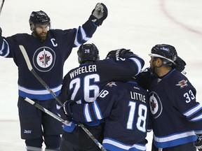 Andrew Ladd (l) celebrates a goal by center Bryan Little against the Nashville Predators on Thursday. (Brian Donogh/Winnipeg Sun/Postmedia Network)