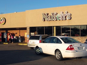 People stop at Naifeh's supermarket in Munford, Tenn., on Jan. 14, 2016, where one of three winning tickets in the record Powerball jackpot was sold. (AP Photo/Adrian Sainz)