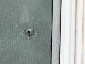 A bullet hole in a second-storey window of a residence at 2676 Innes Rd., where a man was allegedly shot in the leg while sleeping on Friday, Jan. 15, 2016. He was treated and released from hospital. Errol McGihon/Ottawa Sun/Postmedia Network