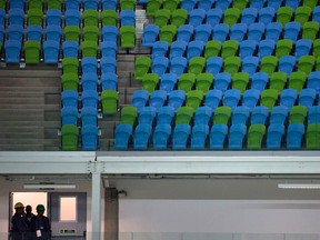 Construction workers stand inside the Carioca Arena 1 at the Olympic Park in Rio de Janeiro, Brazil, Friday, Jan. 15, 2016. Television viewers won't notice when the games open in just over six months, but Rio organizers are slashing everywhere to reduce millions in spending to balance the operating budget. (Leo Correa/AP Photo)