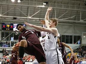 Carleton's Connor Wood leans on Ottawa's Vikas Gill as Carlton defeated Ottawa 93-46 to win the CIS university national basketball championship in Toronto, Ont. on Sunday March 15, 2015. Michael Peake/Toronto Sun/QMI Agency