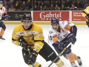 Kingston Frontenacs defenceman Stephen Desrocher and Flint Firebirds forward Will Bitten chase the puck into the corner during the first period of Ontario Hockey League action at the Rogers K-Rock Centre on Friday night. (Elliot Ferguson/The Whig-Standard)