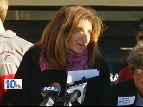 In this Jan. 5, 2016 still image from WJAR-TV video, Sue Stenhouse, left, executive director of the Senior Enrichment Center, speaks alongside a man dressed as an elderly woman, right, during a news conference in Cranston, R.I., to promote a program for school children to help senior citizens shovel snow during the winter. The middle-aged male bus driver wore a wig, earrings, lipstick and a dress, and a tag that read, "Cranston Senior Home Resident." Stenhouse resigned her position after the incident. (WJAR-TV via AP)