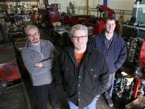 Karl Spafford, left, Neil Candy and Dan Thomas, right, rebuilt a 1932 Ford Coupe that was selected 2015 Hot Rod car of the year. They are pictured in Spafford's workshop in Kingston on Friday, Jan. 15, 2016.
(Elliot Ferguson/The Whig-Standard)
