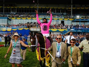 Trainer Mark Casse leads horse Lexie Lou with Patrick Husbands in the irons after winning the 155th running of the Queen’s Plate in 2014. (REUTERS)