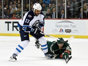 Minnesota Wild defenseman Jared Spurgeon (46) knocks the puck away from Winnipeg Jets defenseman Dustin Byfuglien (33) during the second period of an NHL hockey game Friday, Jan. 15, 2016, in St. Paul, Minn. (AP Photo/Hannah Foslien)