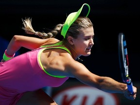 Eugenie Bouchard loses her cap as she reaches out to hits a return to Irina-Camelia Begu during their fourth-round match at the 2015 Australian Open. (REUTERS/Issei Kato)
