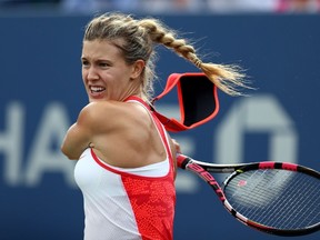 Eugenie Bouchard returns a shot to Dominika Cibulkova as her visor falls off during their match at the 2015 U.S. Open September 4, 2015 in New York City. (Clive Brunskill/Getty Images/AFP)