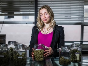 Operations and Marketing Manager at the Toronto Dispensary - Marina, who did not provide her last name -  poses for a photo with jars of marijuana on display the dispensary at Church St. and Wellesley St. E, in downtown Toronto, Ont.  on Tuesday January 12, 2016. Ernest Doroszuk/Toronto Sun/Postmedia Network