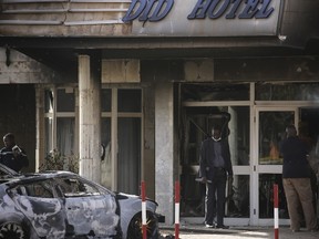 Emergency workers stand outside the burned exterior of the Splendid Hotel in Ouagadougou, Burkina Faso, January 16, 2016, after security forces retook the hotel from al Qaeda fighters who seized it in an assault that killed two dozen people from at least 18 countries and marked a major escalation of Islamist militancy in West Africa.  REUTERS/Joe Penney