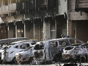A gendarme inspects burnt-out vehicles outside the Splendid Hotel in Ouagadougou, Burkina Faso, January 16, 2016, after security forces retook the hotel from al Qaeda fighters who seized it in an assault that killed two dozen people from at least 18 countries and marked a major escalation of Islamist militancy in West Africa.  REUTERS/Joe Penney