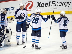 Winnipeg Jets goalie Connor Hellebuyck (30), defenceman Tyler Myers (57), forward Blake Wheeler (26) and forward Mathieu Perreault (85) celebrate following a 1-0 win against the Minnesota Wild at Xcel Energy Center on Friday. (Brace Hemmelgarn-USA TODAY Sports)