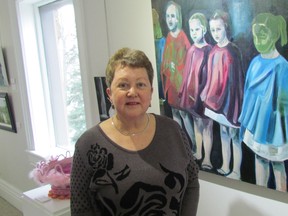 Sheila Brown, chairperson of the Gallery in the Grove Invitation 2016 Juried Art Exhibition, stands with the first prize winning entry, an oil on canvass by Paula McLean, at the show's opening on Sunday January 17, 2016 in Sarnia, Ont. (Paul Morden, Sarnia Observer)