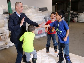 MLA Kevin Chief bounces on a mattress with (left to right) Hayden Chief, Teryden and Tristan McNabb following a mattress recycling press conference at Mother Earth Recycling in Winnipeg, Man. Sunday Jan. 17, 2016. (Brian Donogh/Winnipeg Sun/Postmedia Network)