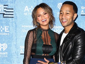 Chrissy Teigen, left, and John Legend pose backstage at the Shining a Light: A Concert for Progress on Race in America held at the Shrine Auditorium on Wednesday, Nov. 18, 2015, in Los Angeles.