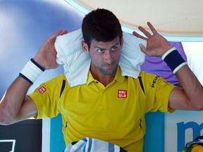 Serbia's Novak Djokovic places an ice pack on his neck during a break in his first round match against South Korea's Hyeon Chung at the Australian Open tennis tournament at Melbourne Park, Australia, January 18, 2016. (REUTERS/Jason Reed)