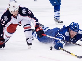 Toronto Maple Leafs defenceman Morgan Rielly battles for the loose puck against Columbus Blue Jackets right winger Cam Atkinson during third period action in Toronto on Jan. 13, 2016. (THE CANADIAN PRESS/Nathan Denette)