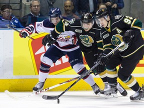 London Knights forward Mitch Marner (93) takes control of the puck as Knights forward JJ Piccinich keeps Saginaw Spirit defenceman Marcus Crawford at bay during their OHL hockey game at Budweiser Gardens in London, Ont. on Friday January 15, 2016. (CRAIG GLOVER, The London Free Press)