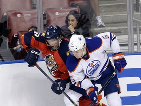 Oilers defenceman Mark Fayne takes Panthers forward Jaromir Jagr against the boards during Monday`s game in Sunrise, Fla. (AP photo)