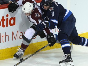 Colorado Avalanche defenceman Tyson Barrie (l) and Winnipeg Jets left winger Alexander Burmistrov fight for the puck during NHL hockey in Winnipeg, Man. Monday January 18, 2016.
Brian Donogh/Winnipeg Sun/Postmedia Network