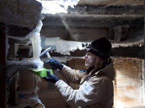 Mawson's Huts Foundation chief conservator, Dr. Ian Godfrey, chips ice from the shelves in Sir Douglas Mawson's bedroom in Mawson's Hut at Cape Denison in Antarctica in this Dec. 11, 2015 handout photo. Conservationists in Australia's oldest Antarctic outpost have scraped away a hundred years of snow and ice to unearth items, from bullets to a bowl of peas, that reveal the harsh conditions battled by early explorer Douglas Mawson and his team. (REUTERS/David Killick/Mawsons Huts Foundation/Handout via Reuters)