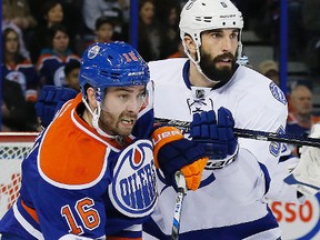 Jan 8, 2016; Edmonton, Alberta, CAN; Edmonton Oilers forward Teddy Purcell (16) and Tampa Bay Lightning defensemen Jason Garrison (5) battle during the third period at Rexall Place. Mandatory Credit: Perry Nelson-USA TODAY Sports