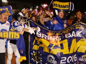 Football fans cheer for the return of the Rams to Los Angele,s on the site of the old Hollywood Park horse-racing track in Inglewood, Calif., on Tuesday, Jan. 12, 2016. NFL owners voted Tuesday night to allow the St. Louis Rams to move to a new stadium at the site just outside Los Angeles, and the San Diego Chargers will have an option to share the facility. (AP Photo/Damian Dovarganes)