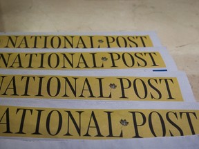 Copies of the Postmedia-owned newspaper National Post are displayed at a hotel in Burnaby, B.C., on Tuesday January 19, 2016. Postmedia has cut approximately 90 jobs and merged newsrooms in four cities as it steps up plans to slash costs amid mounting revenue losses. The company owns two newspapers in each of the cities of Ottawa, Calgary, Edmonton and Vancouver. (THE CANADIAN PRESS/Darryl Dyck)
