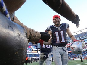 Julian Edelman of the New England Patriots celebrates a win over the Washington Redskins with the Endzone Militia as he runs onto the field before a game with the Washington Redskins at Gillette Stadium in Foxborough, Mass., on Nov. 8, 2015. (Jim Rogash/Getty Images/AFP)