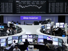 Traders work at their desks in front of the German share price index, DAX board, at the stock exchange in Frankfurt, Germany, January 19, 2016.    REUTERS/Staff/Remote