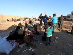 Volunteers from a Kurdish relief organization distribute food to displaced people, who are fleeing violence in Aleppo city and from Islamic State-controlled areas in Raqqa and Deir al-Zor.  (REUTERS/Rodi Said)