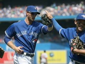 Michael Saunders of the Toronto Blue Jays is congratulated by teammate Devon Travis after making a defensive play during MLB action against the Boston Red Sox on May 9, 2015 at Rogers Centre in Toronto. (Tom Szczerbowski/Getty Images/AFP)