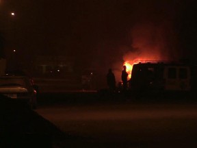 In this grab taken from video by Associated Press Television, armed men approach a vehicle, near to a hotel, in Ouagadougou, Burkina Faso, Friday, Jan. 15, 2016.  (Associated Press Television via AP)