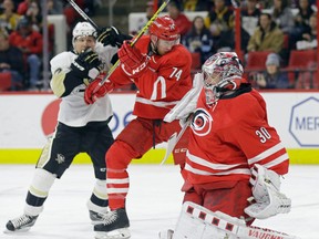Carolina Hurricanes goalie Cam Ward (30) deflects a shot as Hurricanes' Jaccob Slavin and Pittsburgh Penguins' Patric Hornqvist, of Sweden, struggle at rear during the first period of an NHL hockey game in Raleigh, N.C., Tuesday, Jan. 12, 2016. Carolina won 3-2 in overtime. (AP Photo/Gerry Broome)