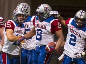 Montreal Alouettes' slotback Nik Lewis (8) celebrates his touchdown against the B.C Lions with teammates Samuel Giguere (15) and Fred Stamps (2) during the first half of their CFL football game in Vancouver, British Columbia, August 20, 2015. REUTERS/Ben Nelms