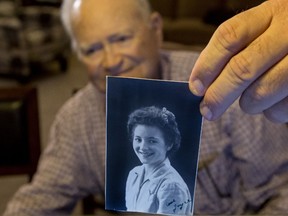 In this photo taken Nov. 6, 2015, Norwood Thomas, 93, holds up a photo of with Joyce Morris at his home in Virginia Beach, Va. During the Second World War, Morris lived in England and was Joyce Durrant, the girlfriend of Thomas, a D-Day paratrooper with the Army's 101st Airborne Division. Morris now lives in Australia. (Bill Tiernan/The Virginian-Pilot via AP)