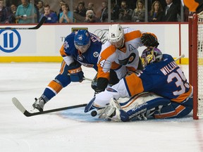 New York Islanders defenceman Adam Pelech (left) looks on as Islanders goalie Stephon Williams (35) makes a save against a shot by Philadelphia Flyers center Sean Couturier (14) at the Barclays Center in New York, Monday, Sept. 21, 2015. (AP Photo/Bryan R. Smith)