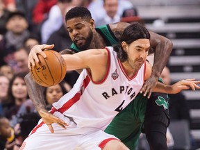 Toronto Raptors forward Luis Scola tries to drive past Boston Celtics forward Amir Johnson during first half NBA basketball action in Toronto on Jan. 20, 2016. (THE CANADIAN PRESS/Nathan Denette)