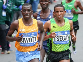 2015 winner and Kenyan runner Stanley Biwott runs with fifth place finisher Yemane Tsegay during the 2015 TCS New York City Marathon. Mandatory Credit: Vincent Carchietta-USA TODAY Sports