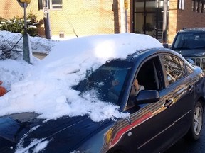 A snow-covered car pulled over by Halifax Regional Police in Halifax on Wednesday, Jan. 20, 2015, is shown in this handout photo. A 37-year-old woman has been ticketed after driving what police have described as a "moving snowbank." Halifax police Const. Diane Woodworth says the woman was stopped on Barrington Street on Wednesday because her car was not properly cleared of snow. THE CANADIAN PRESS/HO - Halifax Regional Police