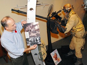 Mike Baker, curator of the Elgin County Museum, places a pictorial poster of waist gunner emplacement in a Mitchell B-25 Bomber mock-up for this 2012 exhibit at the museum.