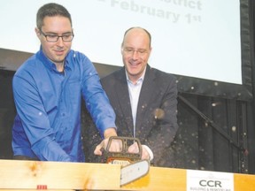 Peter Madsen, left, of CCR Building and Remodeling and Mayor Matt Brown cut a beam with a chainsaw to launch the 2015 Lifestyle Home Show.