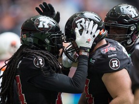 Ottawa Redblacks' Keith Shologan, right, celebrates after recovering a fumble by the B.C. Lions during the first half of a CFL football game in Vancouver, B.C., on Sunday September 13, 2015. THE CANADIAN PRESS/Darryl Dyck