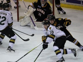 London Knights forward Christian Dvorak protects the puck from Sarnia Sting defenceman Alex Black while circling the net during the Ontario Hockey League game at the Sarnia Sports and Entertainment Centre on Thursday, Jan. 21, 2016 in Sarnia, Ont. Dvorak scored a hat trick and leads the OHL with 36 goals. (Terry Bridge, The Observer)