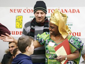 Dr. Remi Ogundimu, president the Sudbury Multicultural Folk Arts Association,  welcomes  Syrian newcomers in Sudbury, Ont. on Thursday, January 21, 2016. The association held a welcome reception at the ParkSide Centre for the newcomers. Gino Donato/Sudbury Star/Postmedia Network