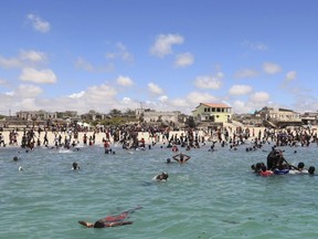 Residents swim in the Indian Ocean waters near Lido beach, north of Somalia's capital Mogadishu in this October 19, 2012 file photo. At least 17 people were killed when Islamist gunmen struck a popular beachside restaurant in the Somali capital of Mogadishu late on Thursday, Somali police said. "The operation ended at 3 a.m. last night and at least 17 civilians were killed," police officer Osman Nur told Reuters on January 22, 2016. REUTERS/Feisal Omar/Files