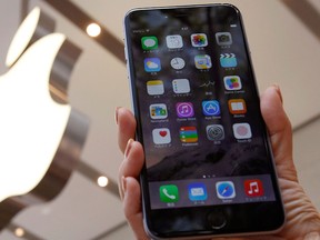 A woman holds up the iPhone 6 Plus at the Apple Store at Tokyo's Omotesando shopping district, in this file photo taken Sept. 19, 2014.   REUTERS/Yuya Shino/Files