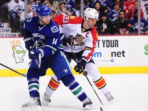 Florida Panthers defenceman Willie Mitchell (33) defends against Vancouver Canucks forward Alexandre Burrows (14) at Rogers Arena. (Anne-Marie Sorvin/USA TODAY Sports)